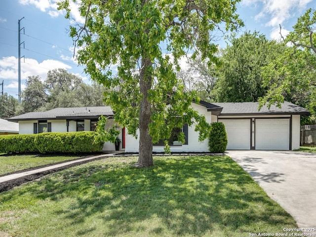 view of front of property with concrete driveway, a front yard, and a garage