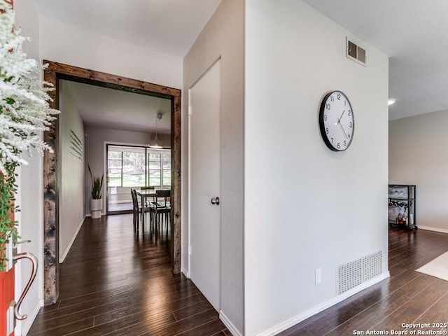 corridor featuring wood finished floors and baseboards