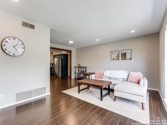 living room with dark wood-style flooring, baseboards, and recessed lighting