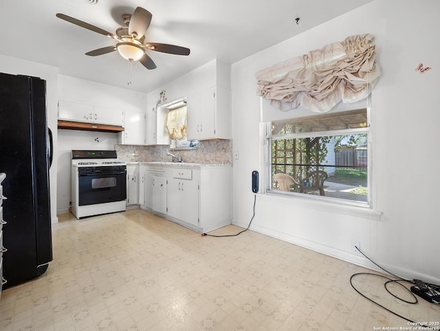 286 Goodhue, San Antonio, TX 78218 - kitchen with gas stove, freestanding refrigerator, light countertops, and white cabinetry