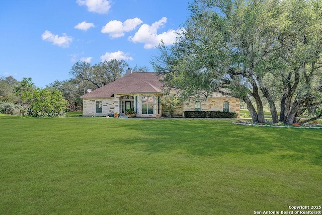 108 Medora Br, Floresville, TX 78114 - french provincial home featuring a front yard, a chimney, and stone siding