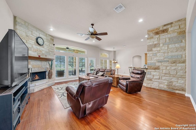 108 Medora Br, Floresville, TX 78114 - living room with a ceiling fan, a fireplace, light wood-style flooring, arched walkways, and recessed lighting
