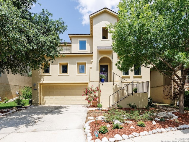 view of property featuring an attached garage, stucco siding, and driveway