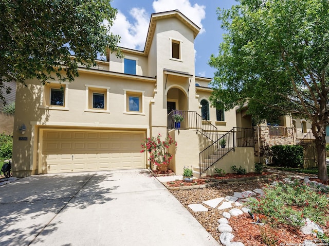 view of front of home featuring stucco siding, concrete driveway, a garage, and stairs