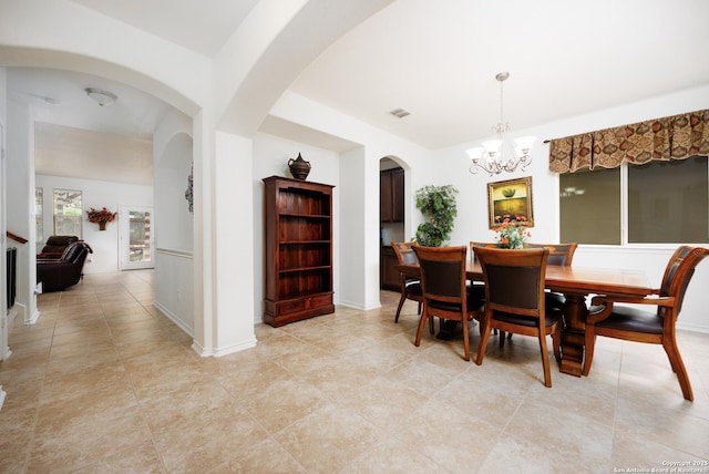 dining room with a chandelier, arched walkways, and light tile patterned flooring