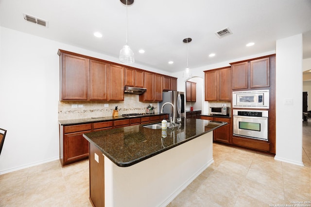 kitchen with appliances with stainless steel finishes, under cabinet range hood, a sink, tasteful backsplash, and recessed lighting