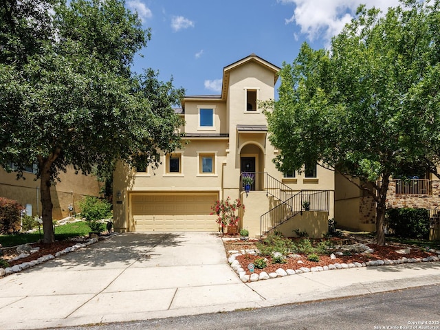 view of front of property with stucco siding, driveway, and a garage