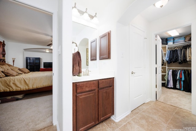 bathroom featuring ceiling fan, connected bathroom, vanity, and a spacious closet