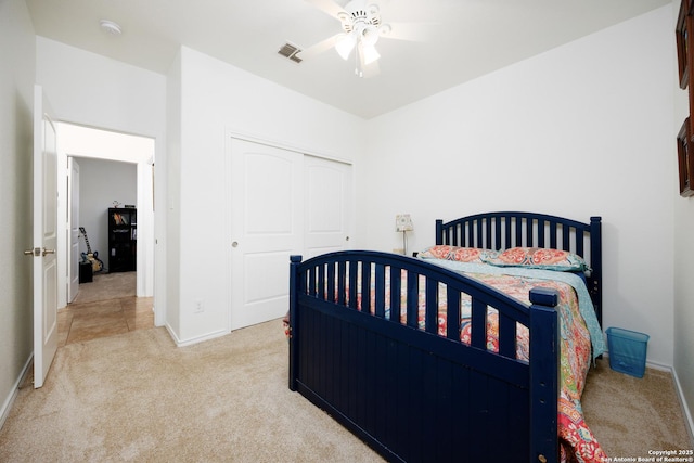 carpeted bedroom with a closet, baseboards, and a ceiling fan