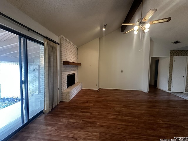 unfurnished living room featuring wood finished floors, ceiling fan, a brick fireplace, and a textured ceiling