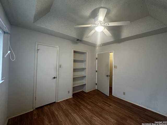 unfurnished bedroom with wood finished floors, a textured ceiling, baseboards, and ceiling fan