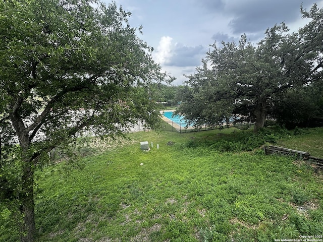 view of green lawn with an outdoor pool