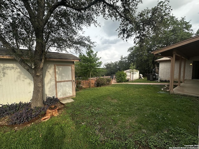 view of yard with a shed, an outdoor structure, and a patio