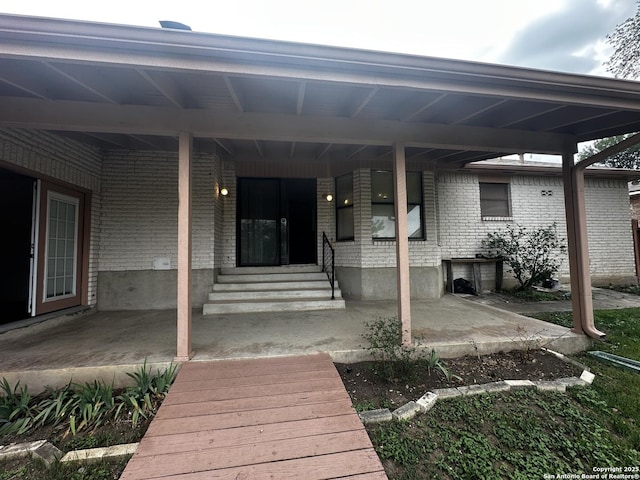 doorway to property with brick siding