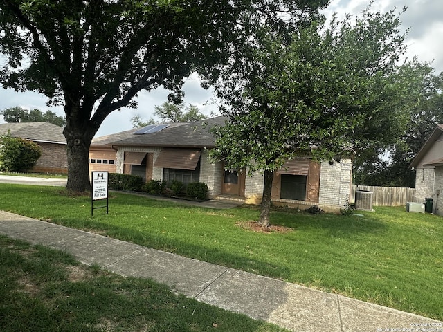 view of front facade featuring an attached garage, central AC, and brick siding