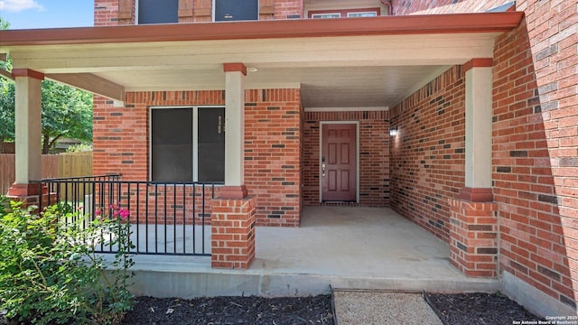 154 Sassafras, Kyle, TX 78640 - property entrance featuring brick siding, covered porch, and fence