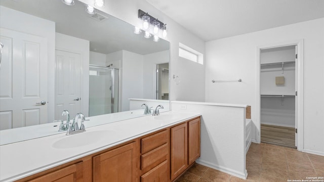154 Sassafras, Kyle, TX 78640 - bathroom with a shower stall, double vanity, baseboards, a walk in closet, and tile patterned flooring