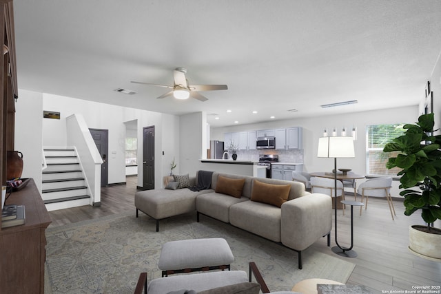 154 Sassafras, Kyle, TX 78640 - living area featuring healthy amount of natural light, light wood-style flooring, ceiling fan, stairway, and recessed lighting