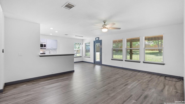 154 Sassafras, Kyle, TX 78640 - unfurnished living room featuring a ceiling fan, wood finished floors, baseboards, and recessed lighting