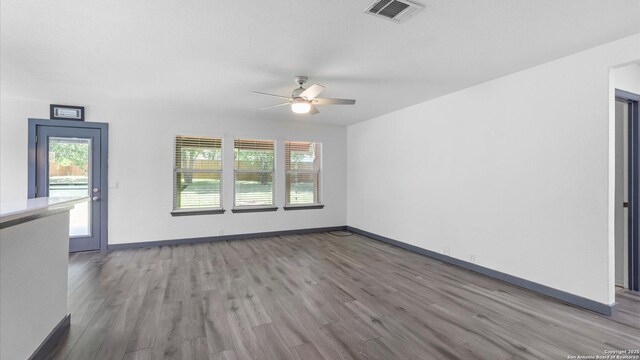 154 Sassafras, Kyle, TX 78640 - spare room with wood finished floors, ceiling fan, and baseboards
