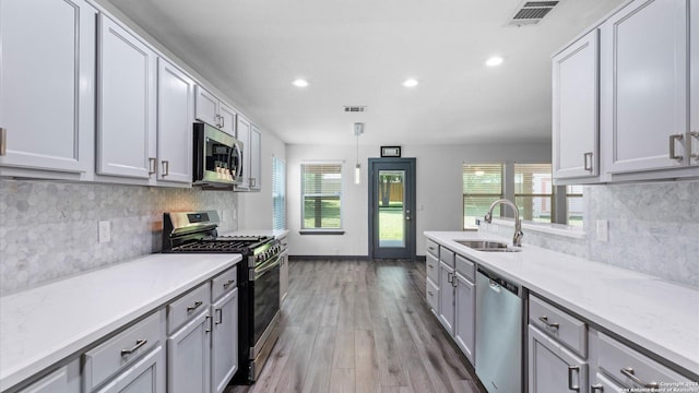 154 Sassafras, Kyle, TX 78640 - kitchen featuring appliances with stainless steel finishes, a sink, wood finished floors, recessed lighting, and healthy amount of natural light