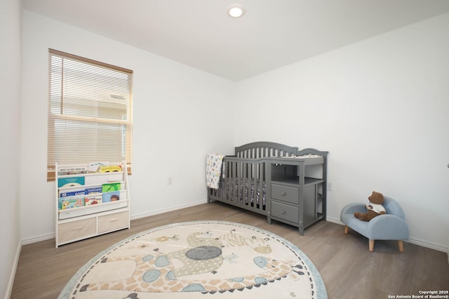 12023 Picard, San Antonio, TX 78221 - bedroom with wood finished floors, baseboards, a crib, and recessed lighting