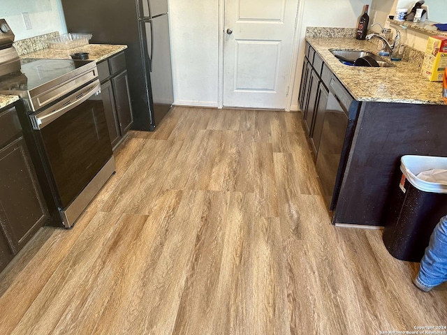 11719 Claudette St, San Antonio, TX 78252 - kitchen with stainless steel appliances, a sink, light wood finished floors, and light stone counters