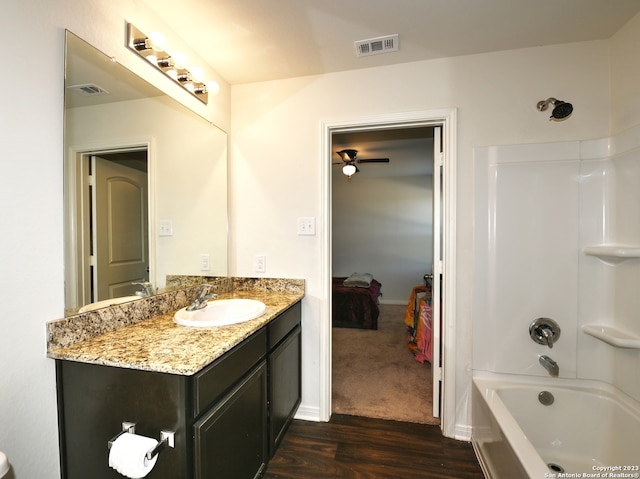 11719 Claudette St, San Antonio, TX 78252 - ensuite bathroom with wood finished floors, vanity, a ceiling fan, and shower / bathtub combination