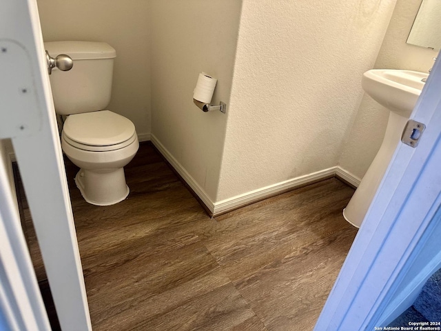 11719 Claudette St, San Antonio, TX 78252 - half bath featuring wood finished floors, toilet, a textured wall, and baseboards