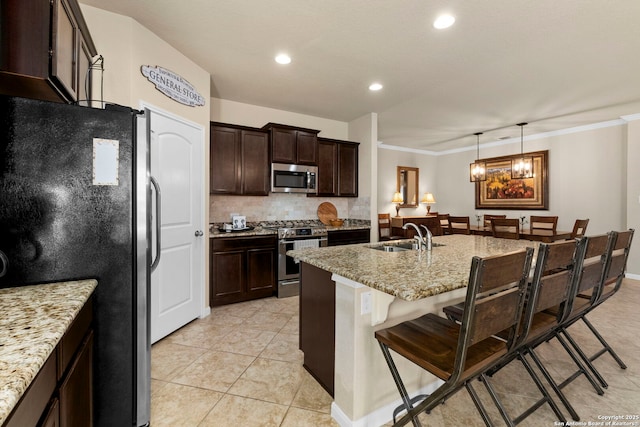 929 Cypress Ml, New Braunfels, TX 78130 - kitchen featuring appliances with stainless steel finishes, a kitchen breakfast bar, a sink, tasteful backsplash, and ornamental molding