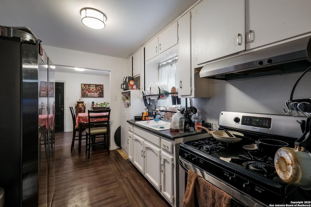 2902 Christian Dr, San Antonio, TX 78222 - kitchen featuring gas stove, under cabinet range hood, freestanding refrigerator, a sink, and dark countertops
