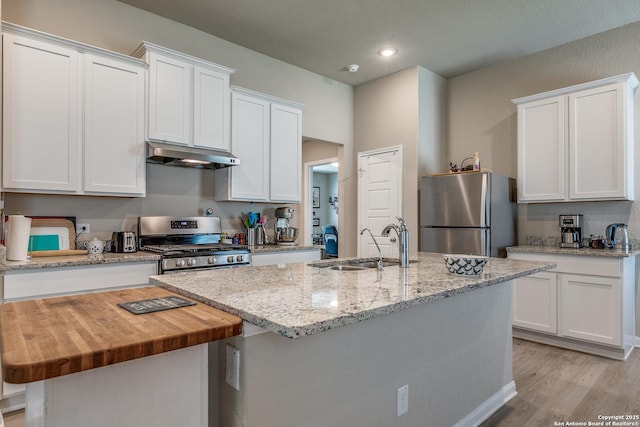 13627 Crossbow, San Antonio, TX 78253 - kitchen with stainless steel appliances, under cabinet range hood, a sink, an island with sink, and white cabinetry