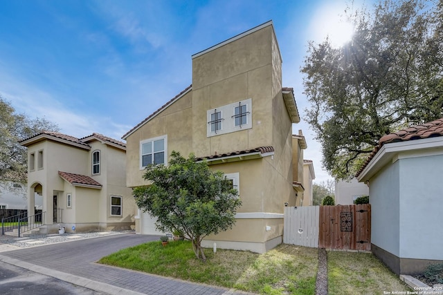 2850 Moncayo Dr, San Antonio, TX 78232 - view of front of home featuring a tiled roof, stucco siding, a gate, and asphalt driveway