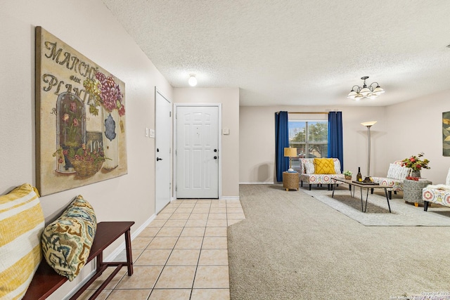 9206 Dancove Dr, San Antonio, TX 78250 - entryway with light tile patterned flooring, a chandelier, a textured ceiling, light colored carpet, and baseboards