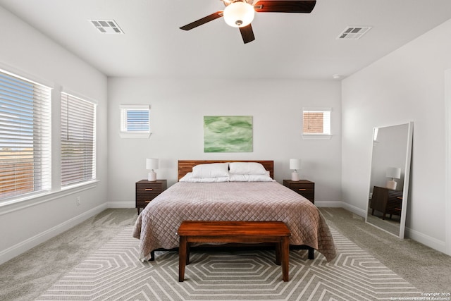 bedroom featuring multiple windows, light colored carpet, baseboards, and ceiling fan