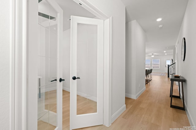 corridor featuring light wood-style flooring, baseboards, stairway, and recessed lighting