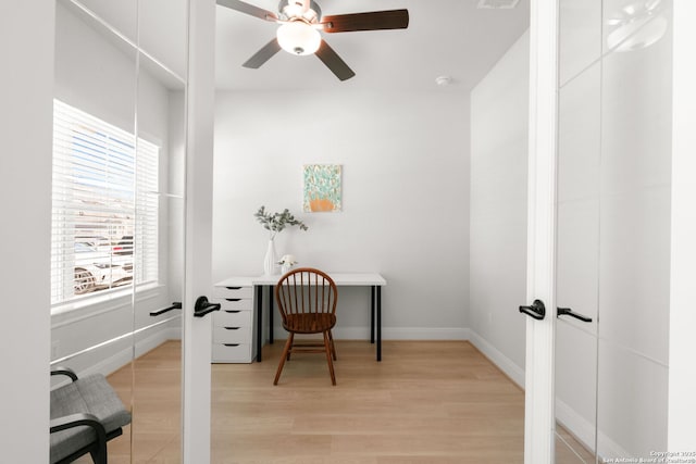 office with light wood-style floors, a ceiling fan, baseboards, and french doors