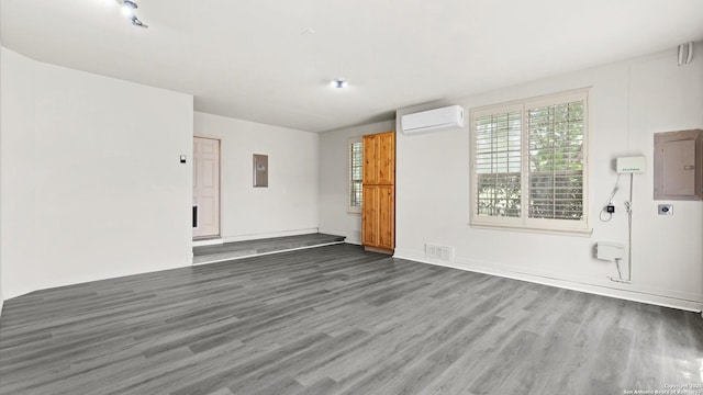 24935 Pecan Crk, San Antonio, TX 78255 - unfurnished room with a wall mounted air conditioner, electric panel, and wood finished floors