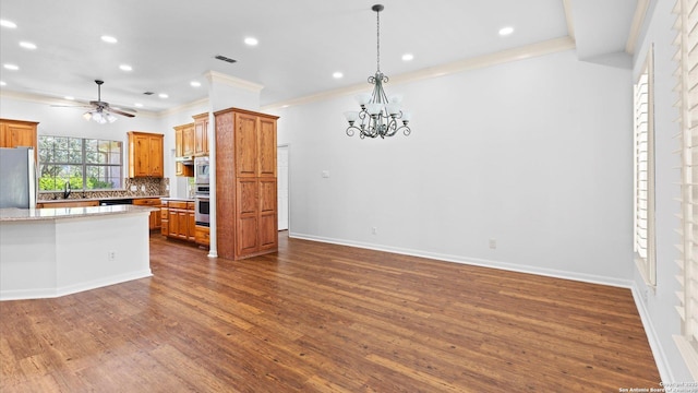 24935 Pecan Crk, San Antonio, TX 78255 - kitchen featuring crown molding, a chandelier, backsplash, brown cabinetry, and ceiling fan