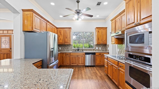24935 Pecan Crk, San Antonio, TX 78255 - kitchen featuring appliances with stainless steel finishes, a sink, crown molding, light wood-type flooring, and ceiling fan
