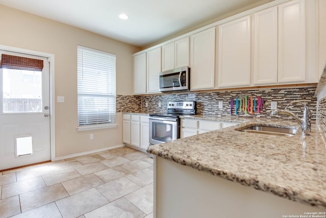 414 Harvest Pt, Selma, TX 78154 - kitchen featuring stainless steel appliances, a sink, tasteful backsplash, white cabinets, and light stone counters