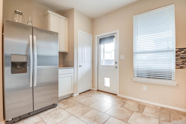 414 Harvest Pt, Selma, TX 78154 - kitchen with stainless steel refrigerator with ice dispenser, white cabinets, baseboards, and light tile patterned floors