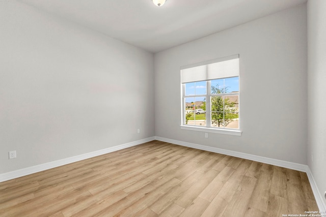 unfurnished room with baseboards and light wood-style floors