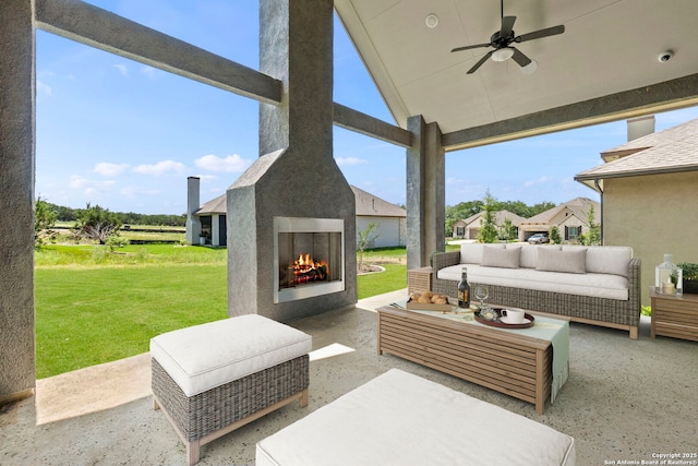 view of patio / terrace featuring an outdoor living space with a fireplace and a ceiling fan