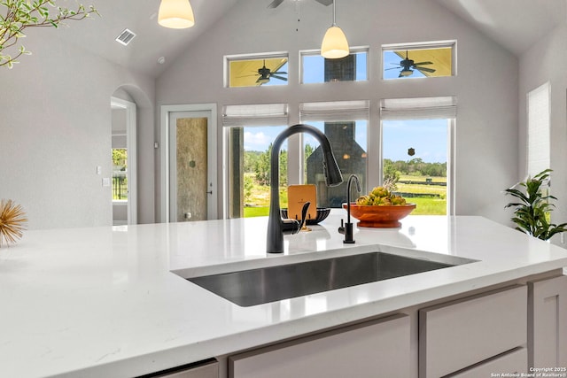 kitchen featuring a sink, high vaulted ceiling, a ceiling fan, healthy amount of natural light, and pendant lighting