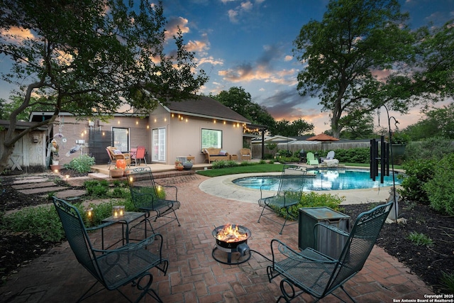 635 Brightwood Pl, San Antonio, TX 78209 - pool at dusk with a fire pit, fence, and a patio