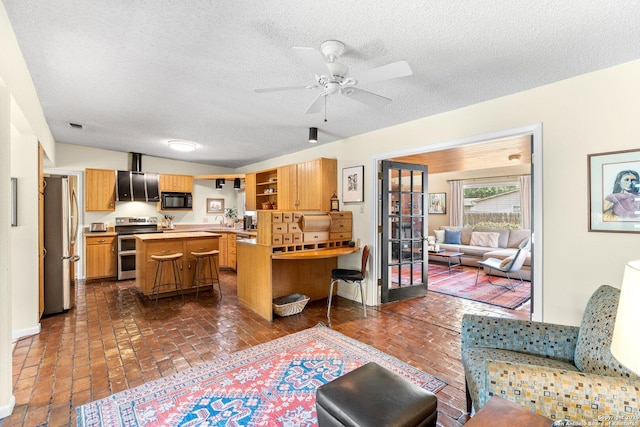 635 Brightwood Pl, San Antonio, TX 78209 - living area featuring a textured ceiling, ceiling fan, brick floors, and baseboards