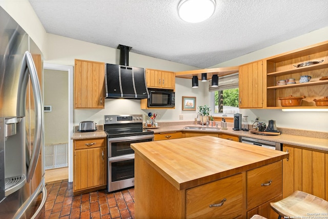 635 Brightwood Pl, San Antonio, TX 78209 - kitchen featuring appliances with stainless steel finishes, wooden counters, a sink, a textured ceiling, and a center island