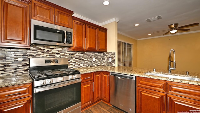 8526 Glen Breeze, San Antonio, TX 78239 - kitchen with stainless steel appliances, a sink, a ceiling fan, crown molding, and dark wood finished floors