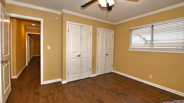 8526 Glen Breeze, San Antonio, TX 78239 - unfurnished bedroom with two closets, dark wood finished floors, baseboards, crown molding, and ceiling fan
